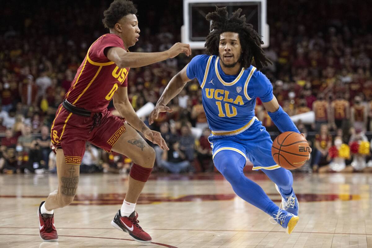 UCLA's Tyger Campbell drives to the basket against USC's Boogie Ellis during the first half.