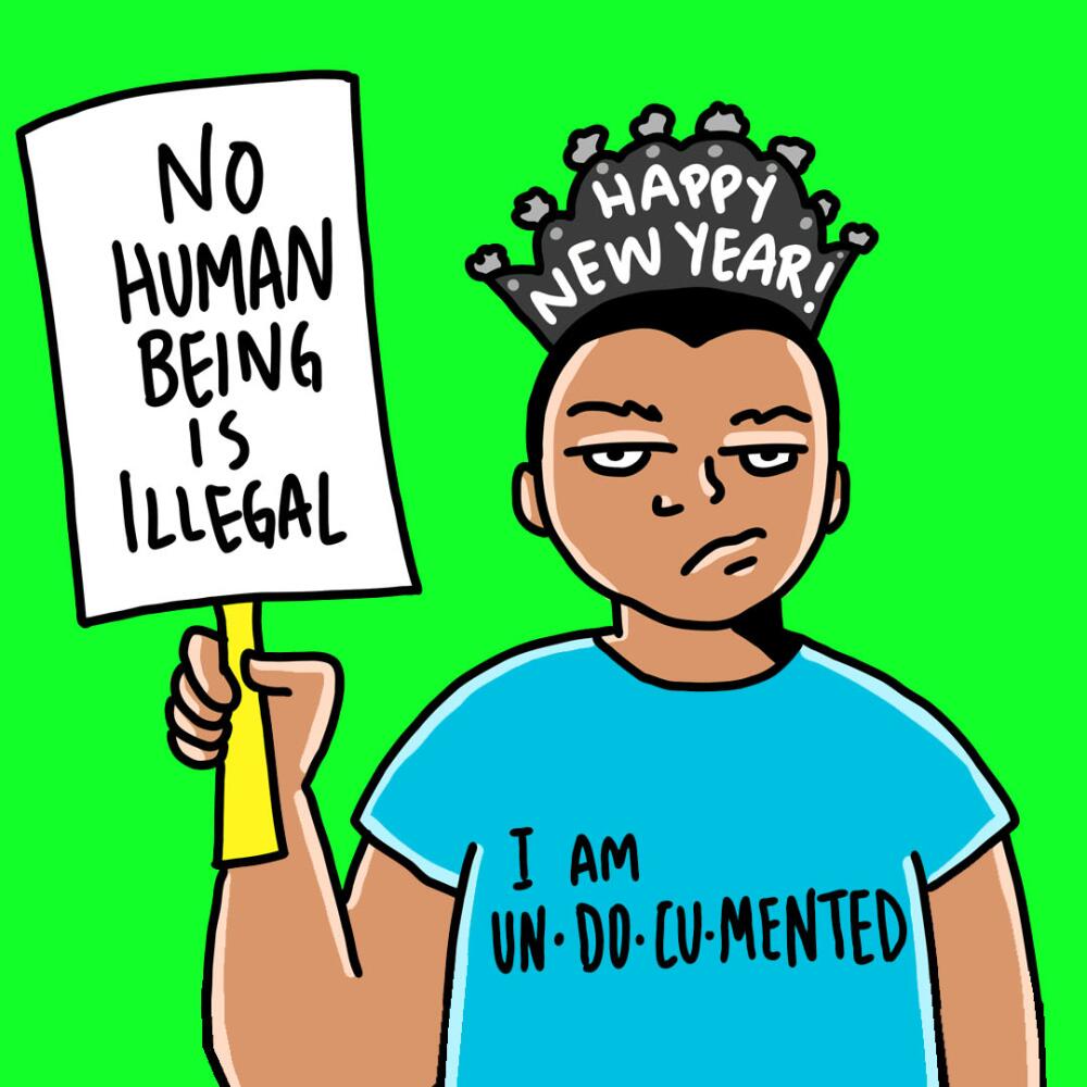 Man holding a sign reading "No human being is illegal."