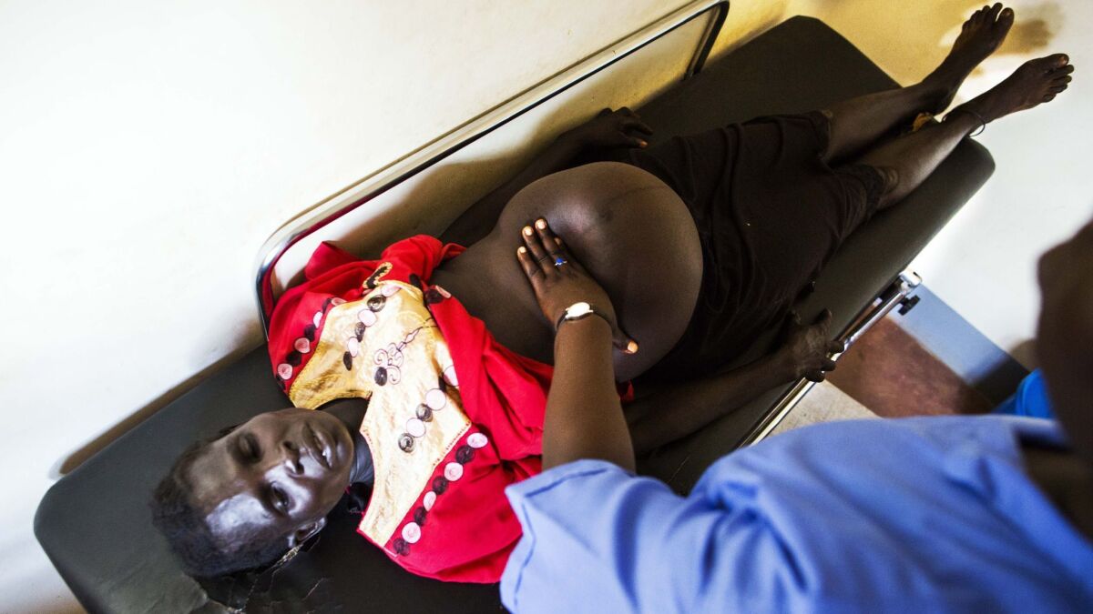 A nurse examines a pregnant woman in South Sudan.