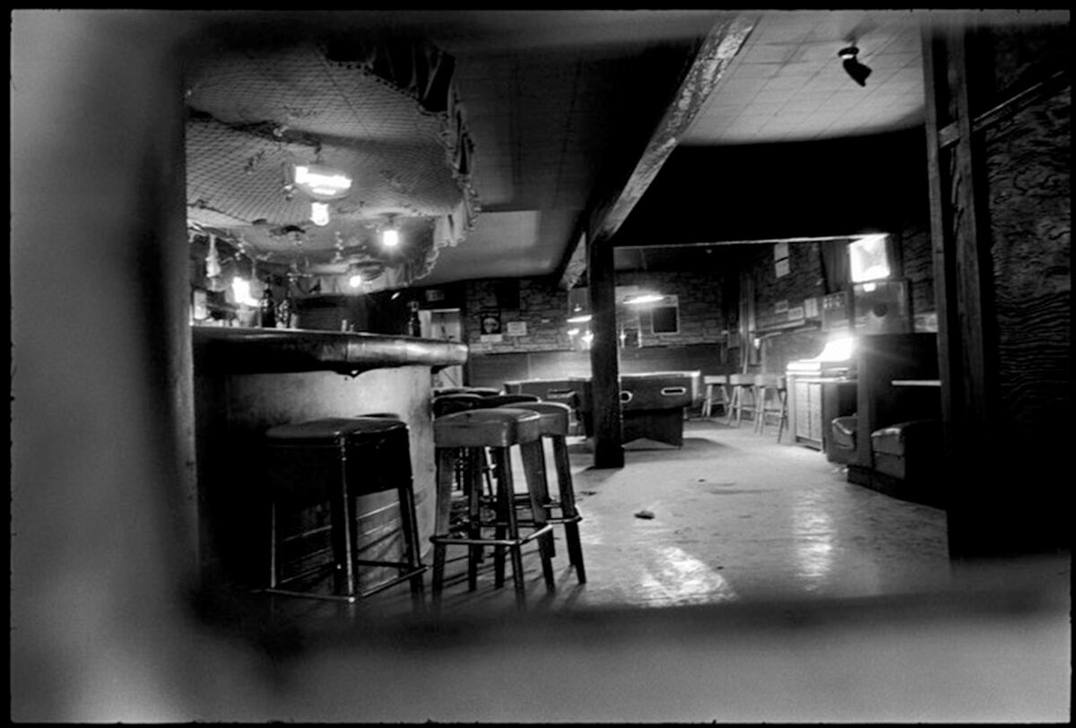 A vintage image shows a bar and pool tables inside the Silver Dollar Café
