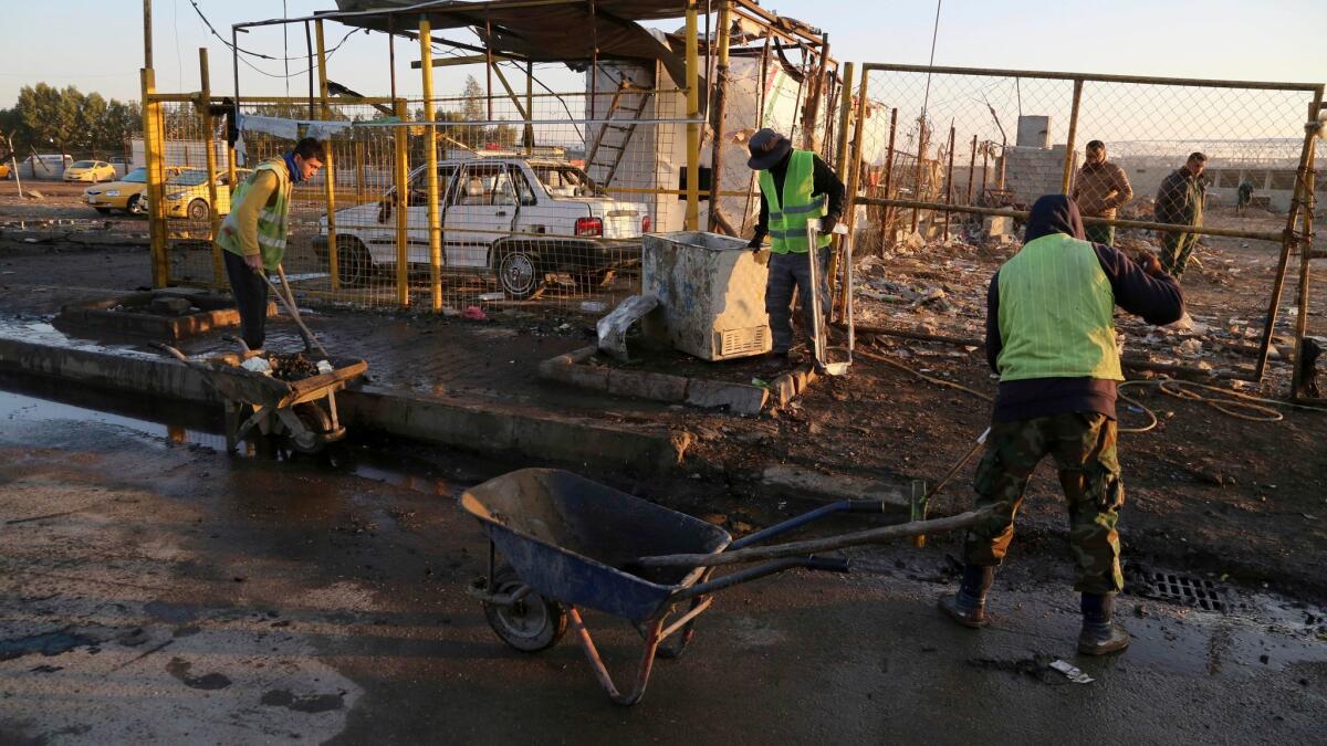 Workers clean the area after a car bomb attack in Baghdad on Feb. 16.