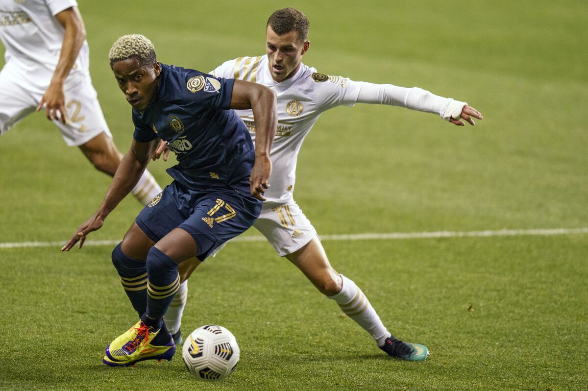 Philadelphia Union's Sergio Santos, left, battles with Atlanta United's Brooks Lennon, right, for the ball during the first half of a CONCACAF Champions League soccer match, Tuesday, May 4, 2021, in Chester, Pa. (AP Photo/Chris Szagola)