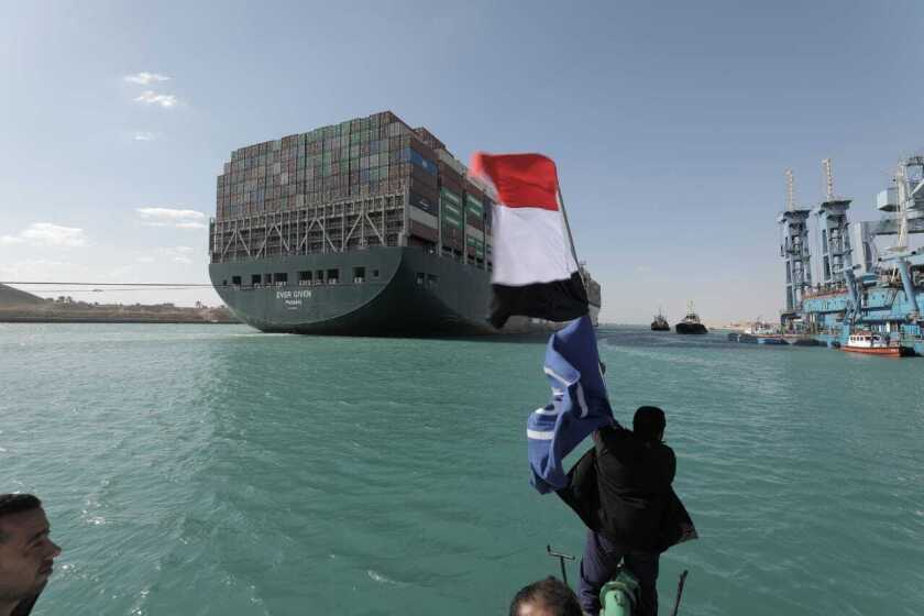 In this photo released by Suez Canal Authority, the Ever Given, a Panama-flagged cargo ship is accompanied by Suez Canal tugboats as it moves in the Suez Canal, Egypt, Monday, March 29, 2021. Salvage teams on Monday set free a colossal container ship that has halted global trade through the Suez Canal, bringing an end to a crisis that for nearly a week had clogged one of the world's most vital maritime arteries. (Suez Canal Authority via AP)