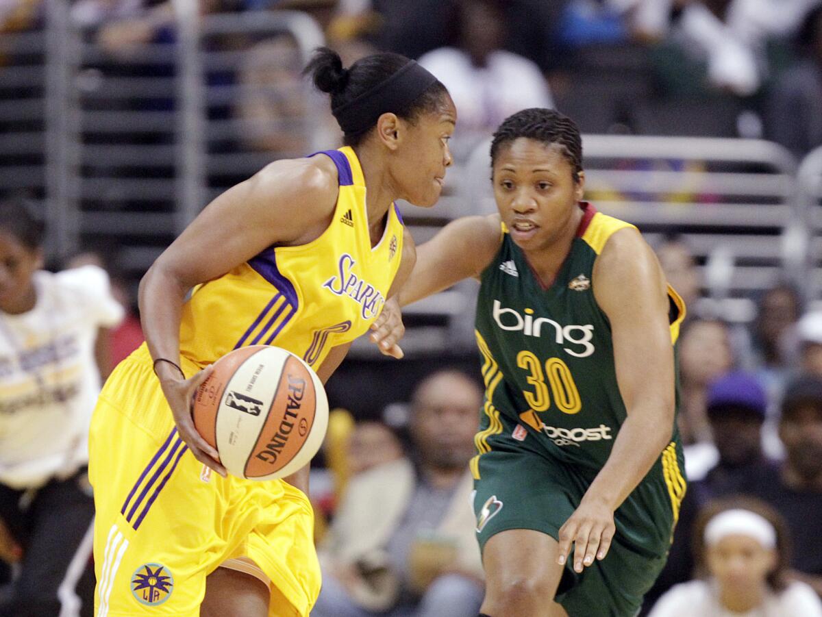 Sparks forward Alana Beard, left, drives against Storm guard Tanisha Wright in the first half of a game last month at Staples Center.