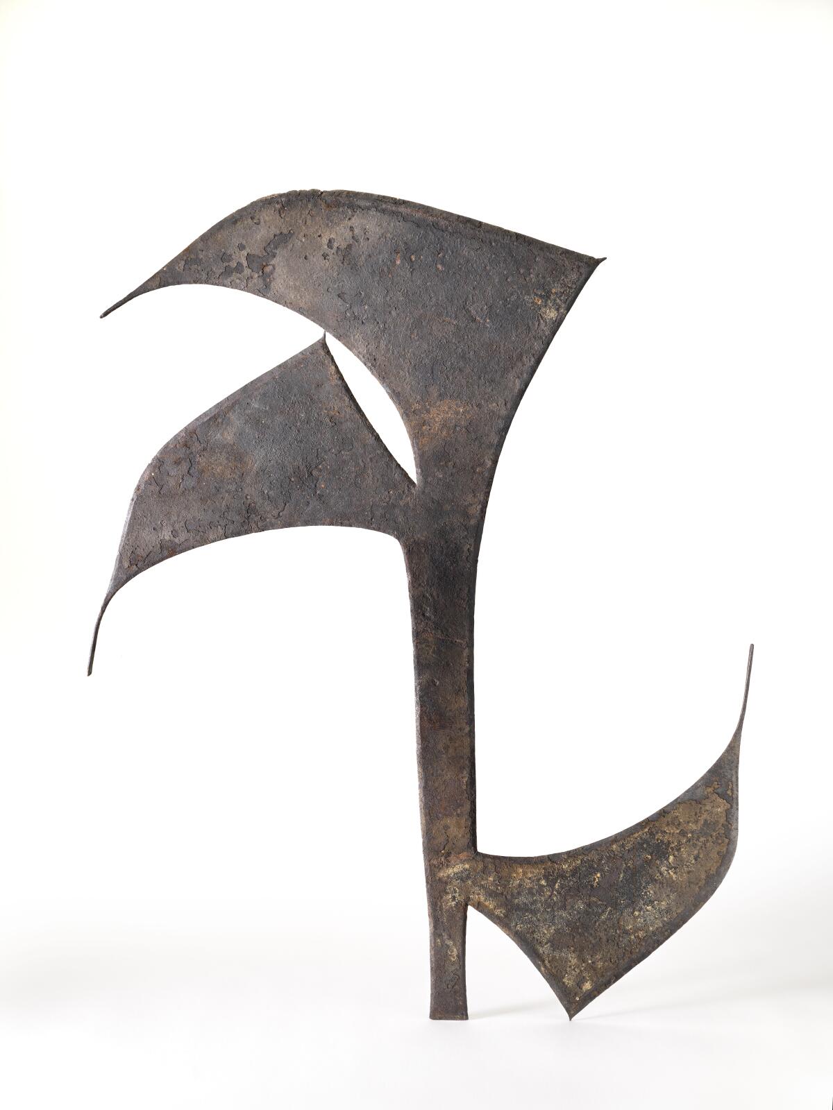 A 19th century African throwing knife is seen in profile bearing three stylized, aerodynamic blades
