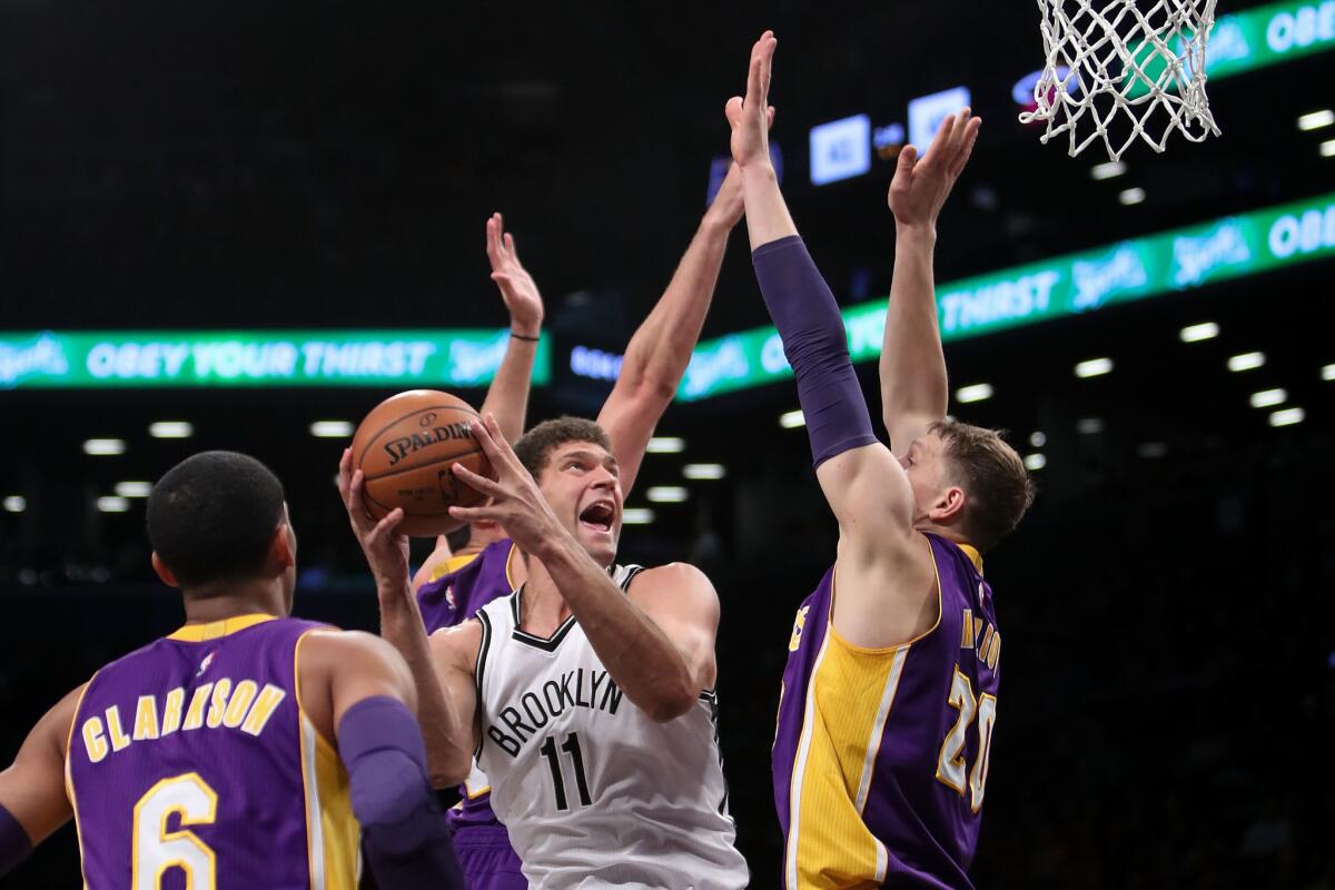 Brook Lopez de los Nets de Brooklyn supera la defensa de los Lakers de Los Ángeles.