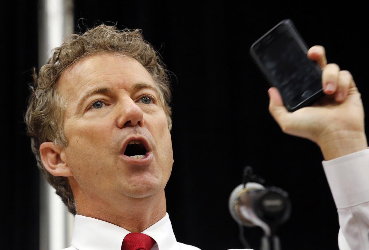 Sen. Rand Paul (R-Ky.) holds up a cellphone to make a point about government eavesdropping during a speech this month in Arizona.