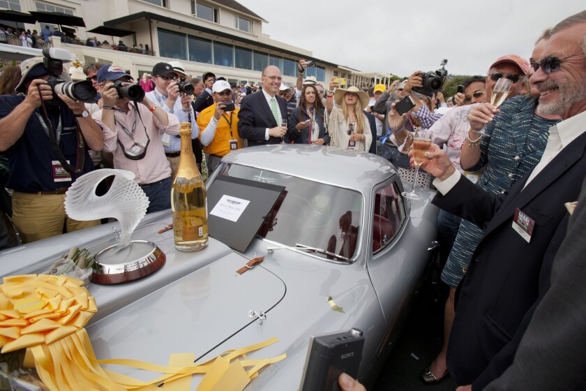 Jon Shirley, who won the best of show at the 2014 Pebble Beach Concours d'Elegance with a 1954 Ferrari 375 MM Scaglietti Coupe, celebrates as fans crowd around the car.