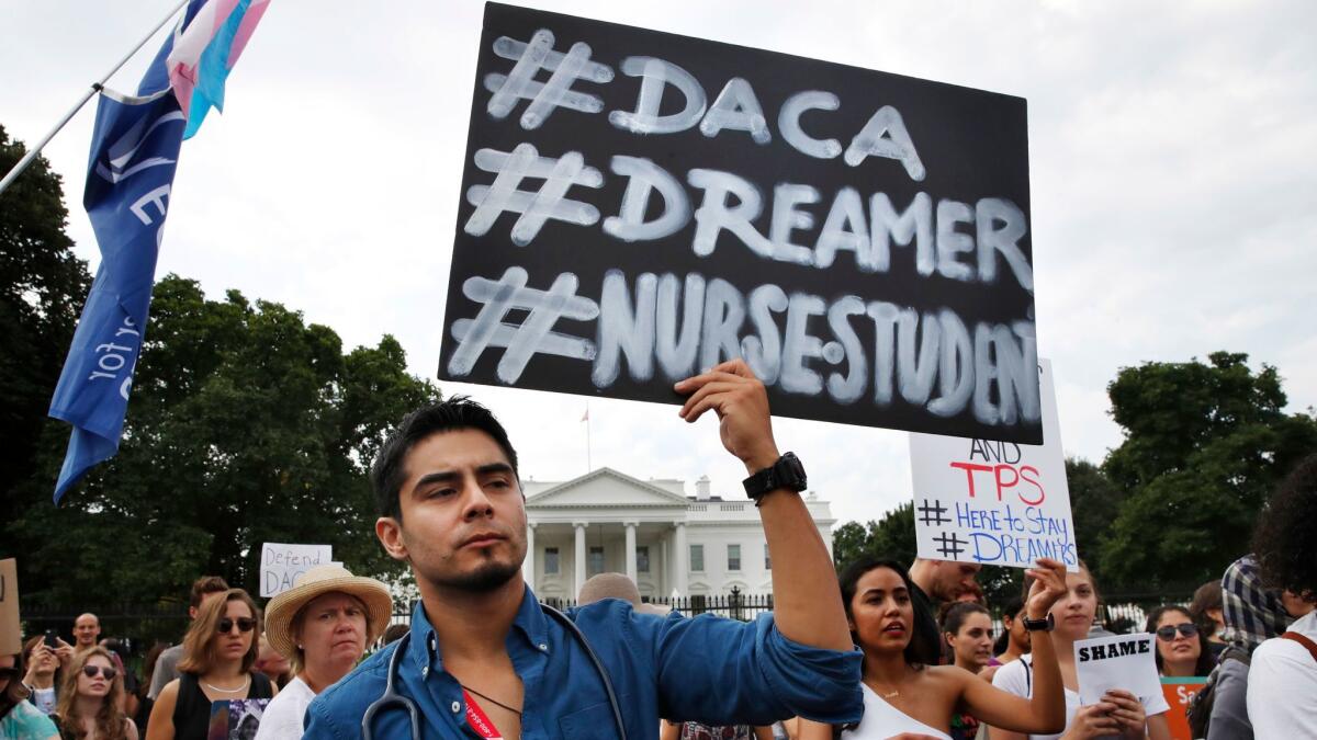 Carlos Esteban of Woodbridge, Va., a nursing student and recipient of Deferred Action for Childhood Arrivals, known as DACA, rallies with others in support of DACA outside of the White House, in Washington, Tuesday.