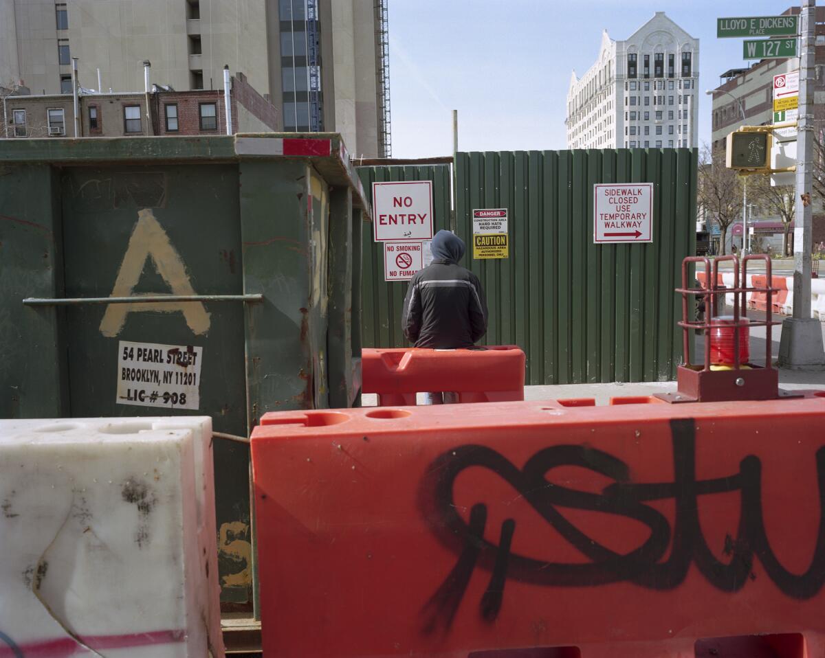 A photo of a young man standing in a construction zone in New York.