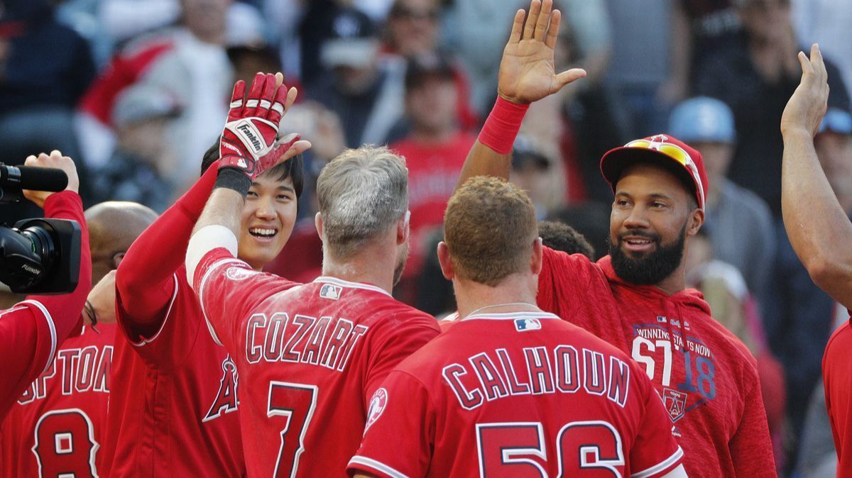 Angels second baseman Zack Cozart (7) is congratulated after hitting a walk-off home run to lift the Angels 3-2 over the Cleveland Indians in 13 innings.