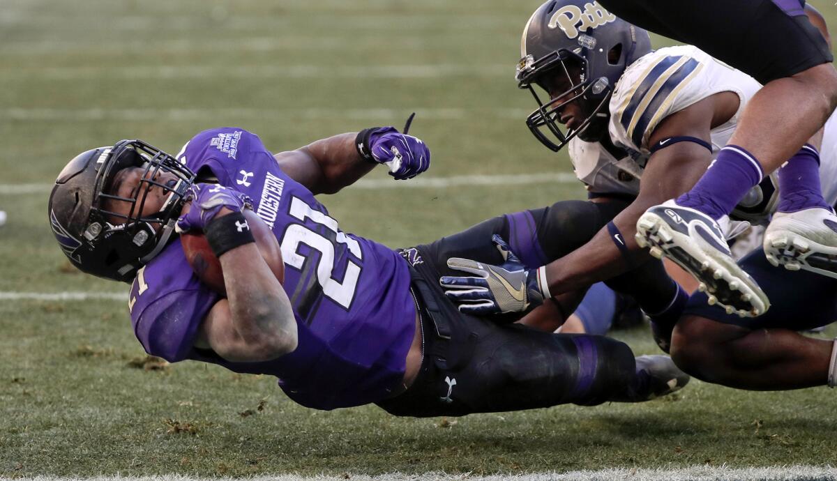 Northwestern running back Justin Jackson (21) falls across the goal line for a touchdown before Pittsburgh linebacker Oluwaseun Idowu can bring him down during the second quarter Wednesday.