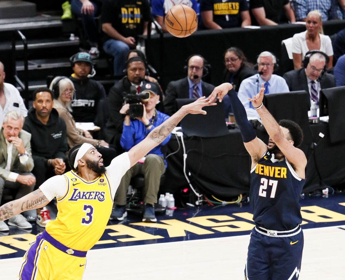 Denver Nuggets guard Jamal Murray scores a three-pointer over Lakers forward Anthony Davis.