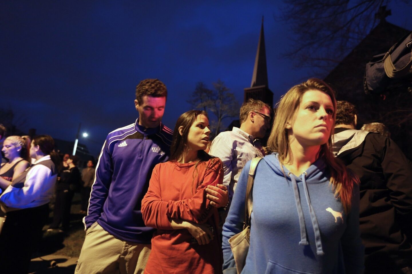People watch as police arrive in Watertown, Mass., where shots were reportedly fired and Boston Marathon bombing suspect Dzhokhar Tsarnaev, 19, was reportedly taken into police custody.