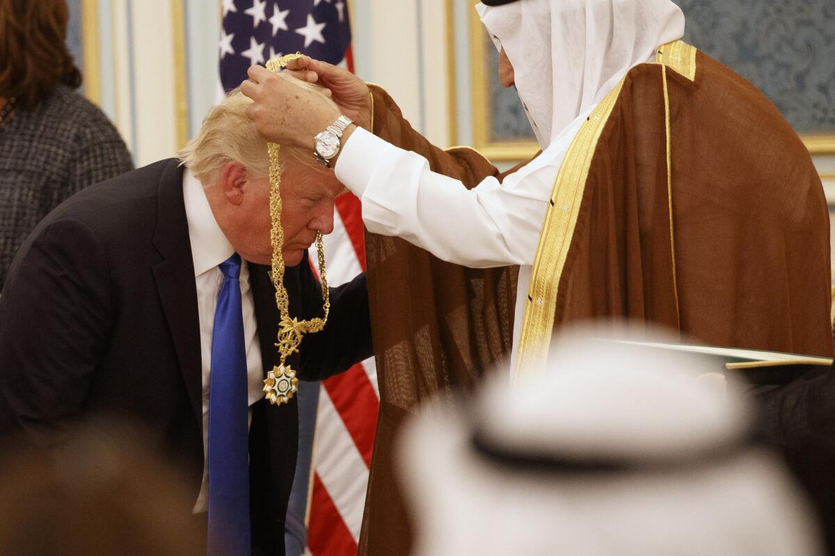 Saudi King Salman presents President Trump with the Collar of Abdulaziz al Saud medal at the Royal Court Palace in Riyadh, Saudi Arabia, on Saturday.