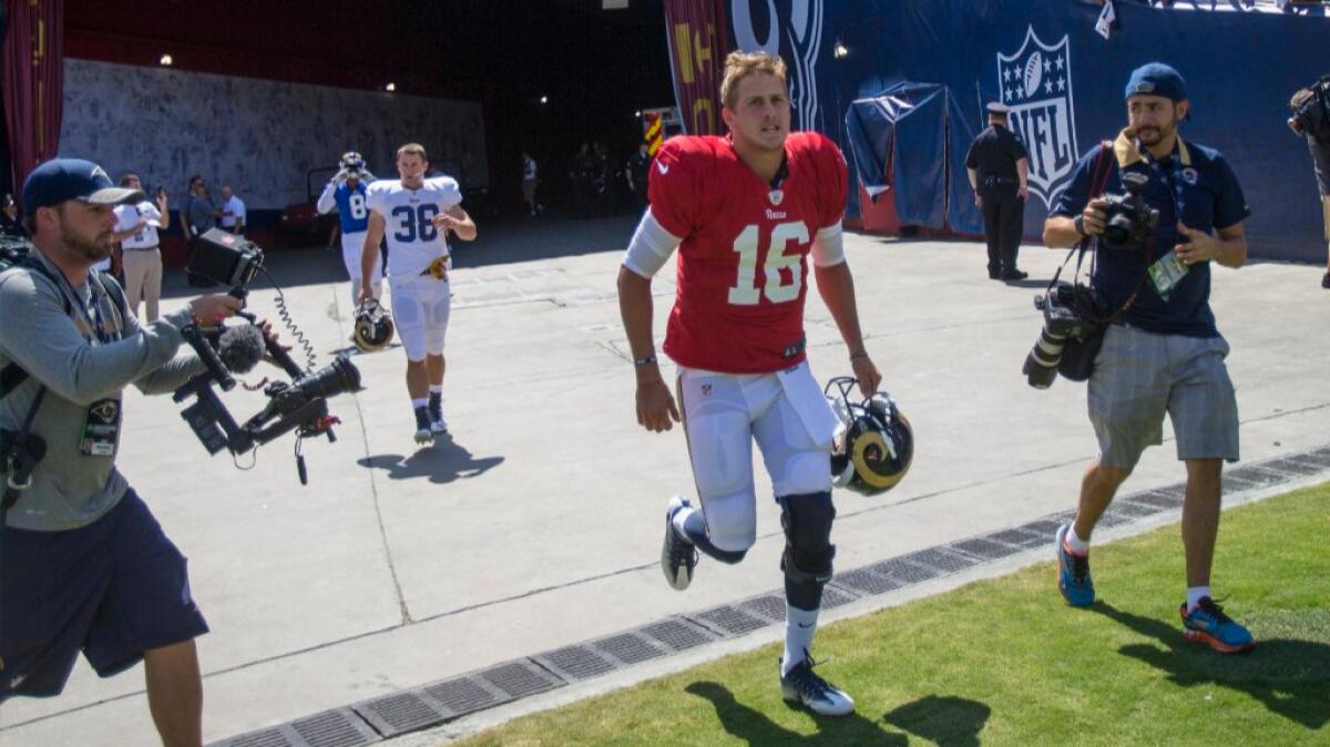 Rams rookie quarterback Jared Goff runs onto the field at the Coliseum before a scrimmage on Aug. 6.