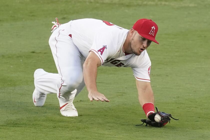 Los Angeles Angels center fielder Mike Trout reaches to catch a ball hit by Texas Rangers' Isiah Kiner-Falefa.