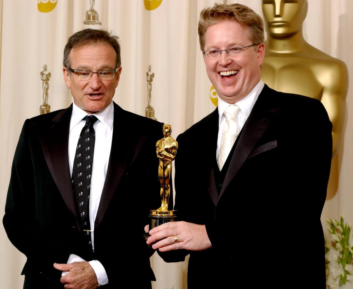 Robin Williams with Andrew Stanton, holding his animated feature film Oscar.