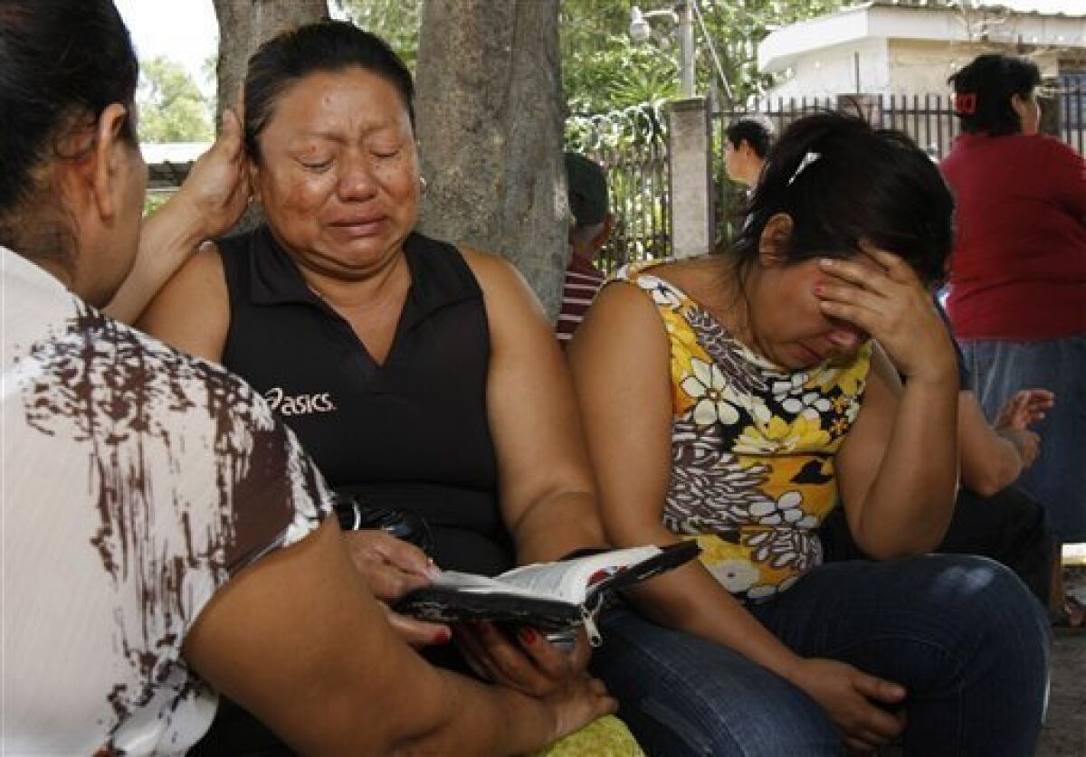 Zuleyma Martinez, center, reacts as she waits for the remains of her son outside the morgue in San Salvador, Monday, June 21, 2010. Martinez's son was killed during an attack to a public bus Sunday night in the northern area of San Salvador, killing at least 10 people who were aboard and leaving several others badly hurt. (AP Photo/Luis Romero)