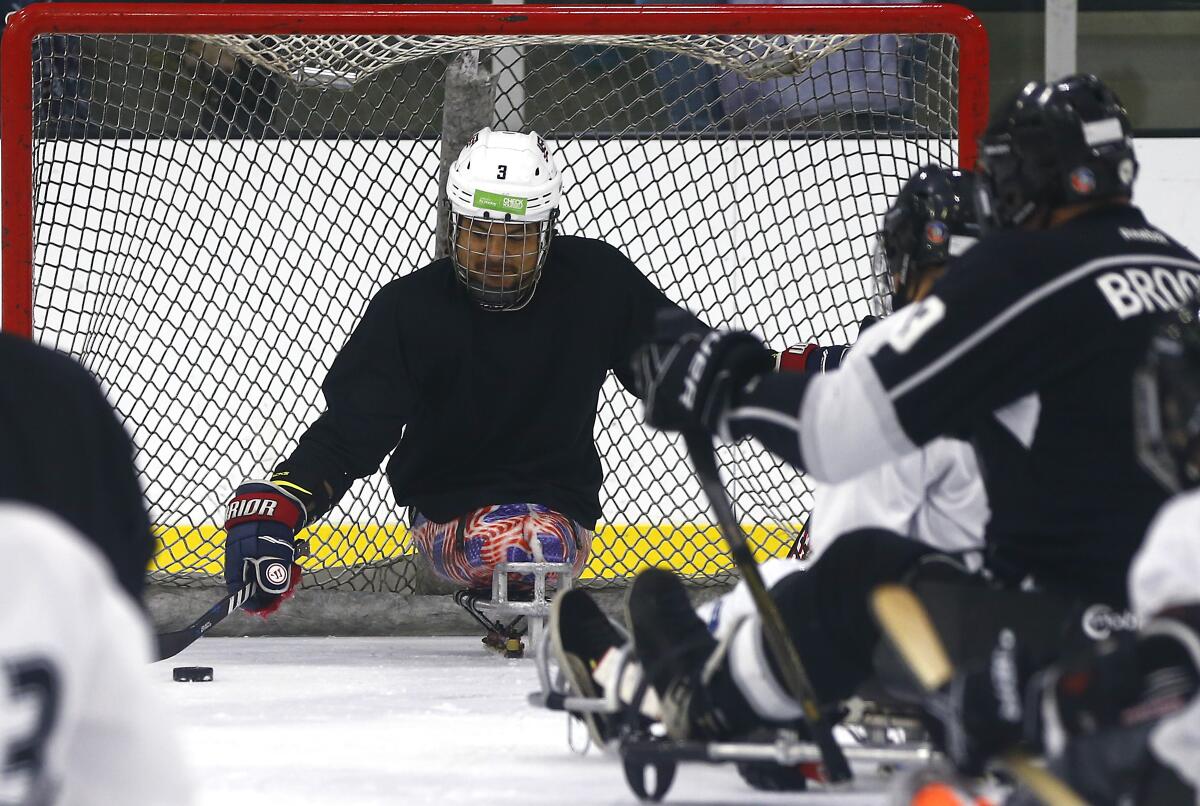 Ralph DeQuebec goaltends during a sled hockey clinic at Great Park Ice rinks in Irvine on Saturday.