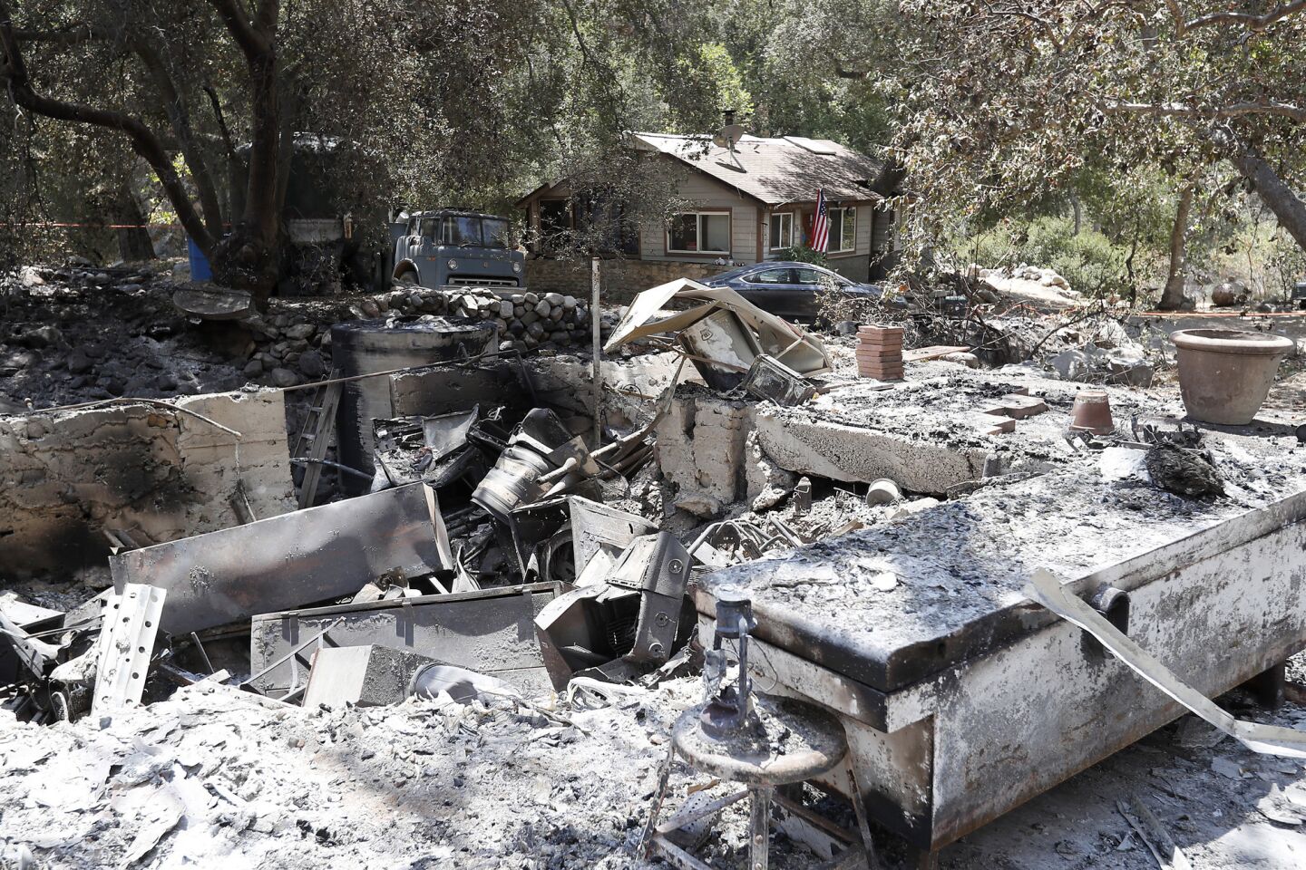 The Trabuco Canyon home of arson suspect Forrest Gordon Clark, 51, stands untouched amid charred remains in his neighborhood.