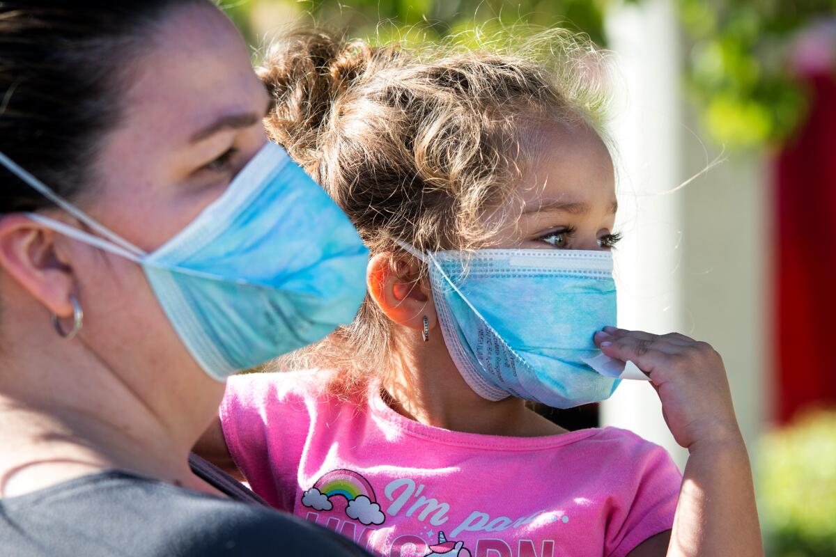 A mother and daughter, both evacuees of the Tick fire near Santa Clarita, wear respirator masks. 