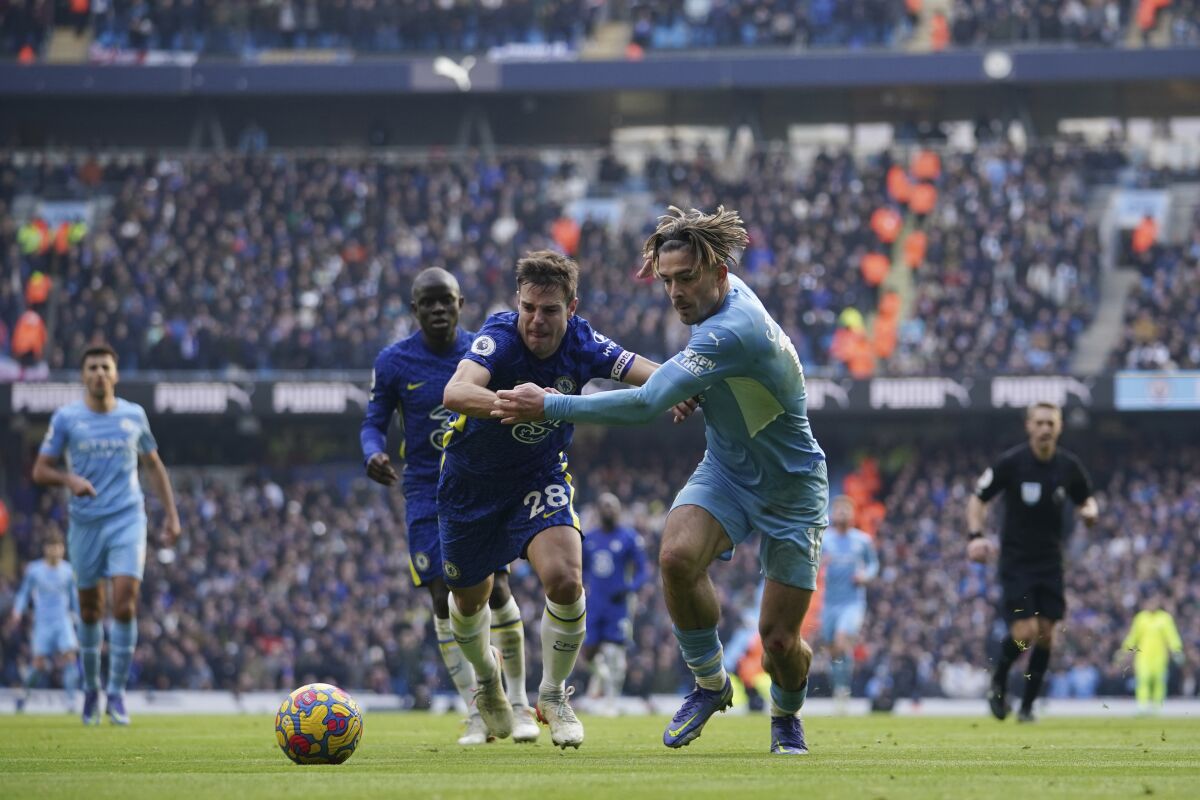 Manchester City's Jack Grealish, centre right, challenges for the ball with Chelsea's Cesar Azpilicueta during an English Premier League soccer match between Manchester City and Chelsea at the Etihad stadium in Manchester, England, Saturday, Jan. 15, 2022. (AP Photo/Dave Thompson)