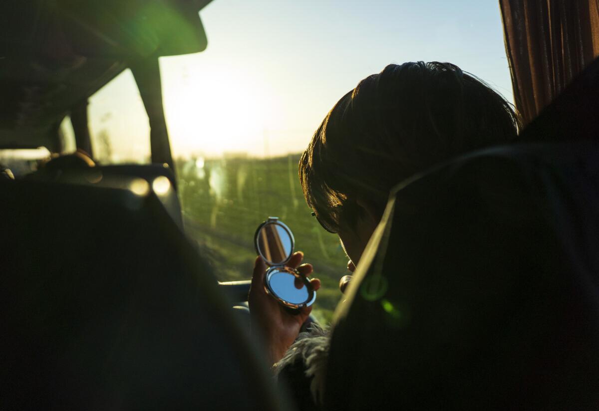 A woman examines her reflection. (Angel Navarrete for Los Angeles Times)