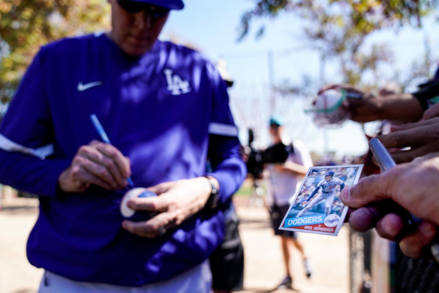 Robert Quesada of Beaumont holds Orel Hershiser's rookie card while he waits for the former Dodgers pitcher to autograph it during spring training.