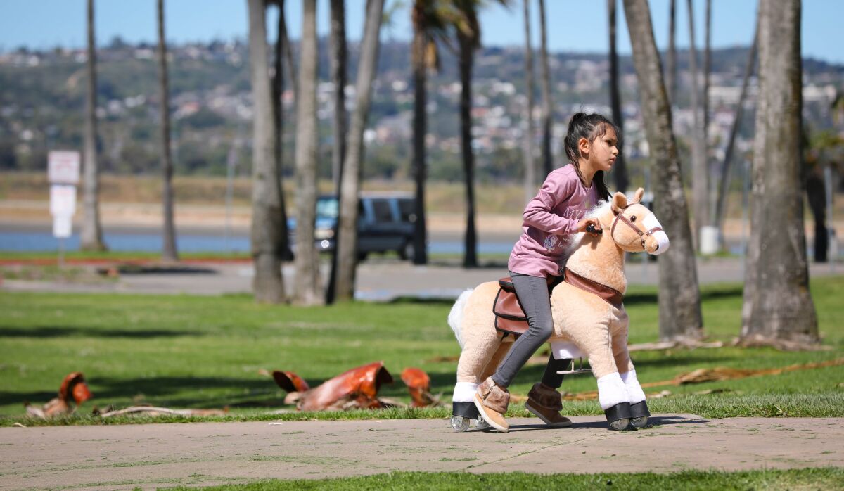 A kindergartner rides her toy horse in San Diego