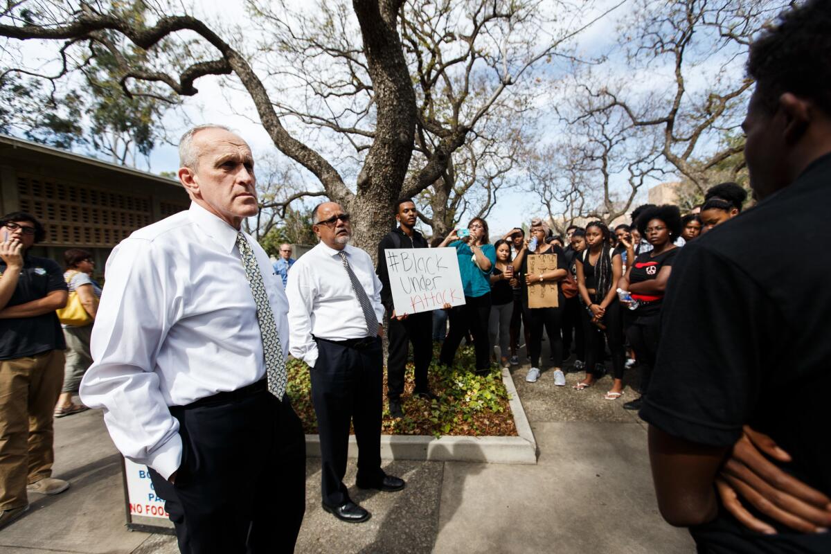 UC Riverside Chancellor Kim Wilcox, left, is confronted by students during a campus protest over racial issues in March 2016.