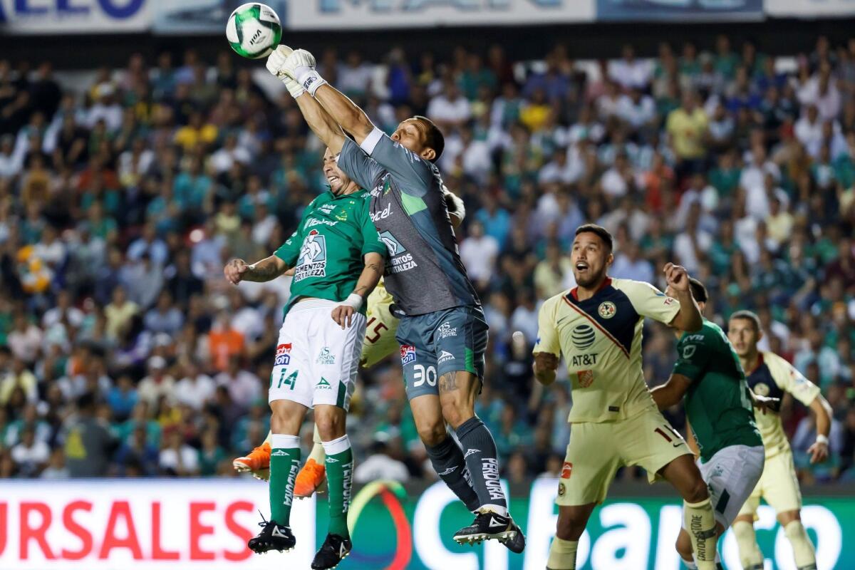 El portero de León Rodolfo Cota (c) despeja el balón ante un ataque de América este jueves, durante un partido de ida de las semifinales del Torneo Clausura 2019 realizado en el Estadio Corregidora, en la ciudad mexicana de Querétaro (México).