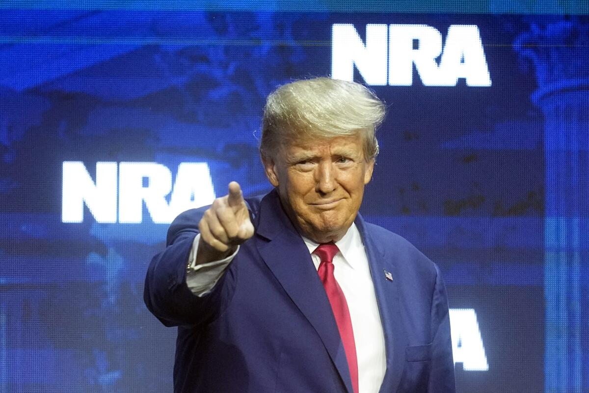 El expresidente Donald J. Trump señala con el dedo durante la convención de la Asociación Nacional del Rifle,