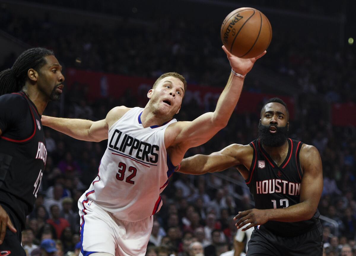 Clippers forward Blake Griffin reaches for a rebound between Rockets guard James Harden, right, and center Nene Hilario during the first half.