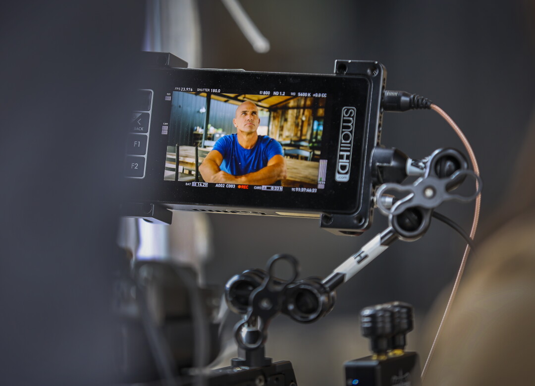 Un moniteur vidéo montre Kelly Slater en train d'être interviewé par la caméra.