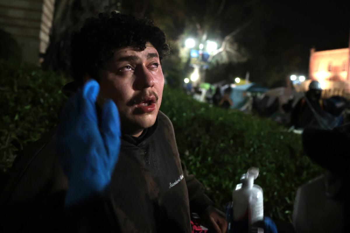 A pro-Palestinian protester washes his eyes from mace