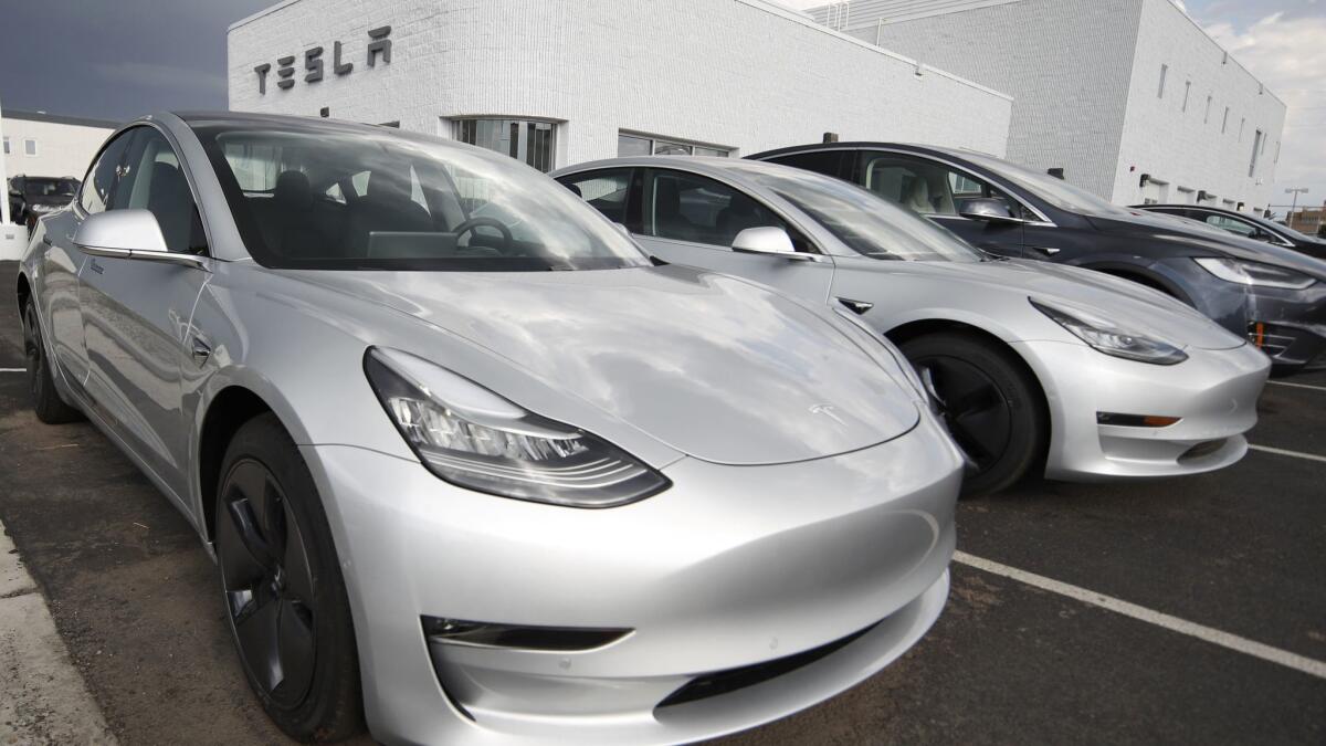 Model 3 sedans sit on display outside a Tesla showroom in Colorado in July. Tesla CEO Elon Musk acknowledged Sunday that the company is now in "delivery logistics hell."