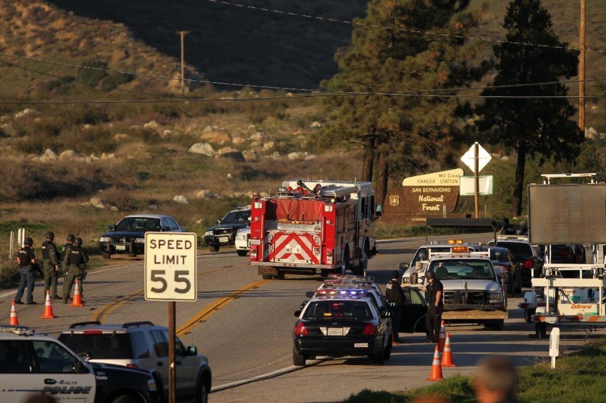 Firefighters pass a roadblock on Highway 38 toward Big Bear Lake as a standoff with former Los Angeles police officer Christopher Dorner continued Tuesday.