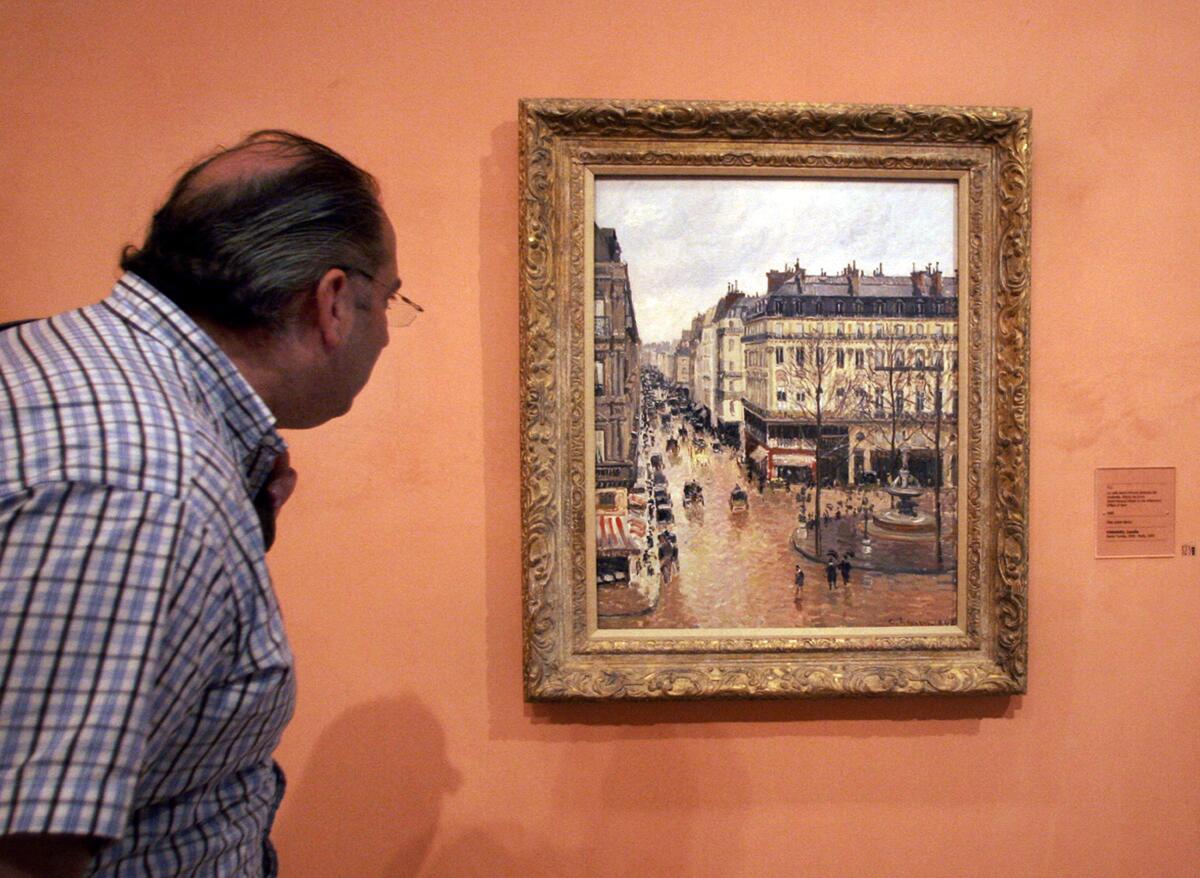 A man looks at a painting.