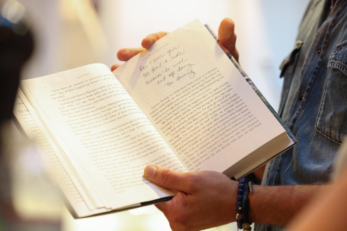 A closeup of a page of John Stamos' memoir, with a handwritten note at the top.