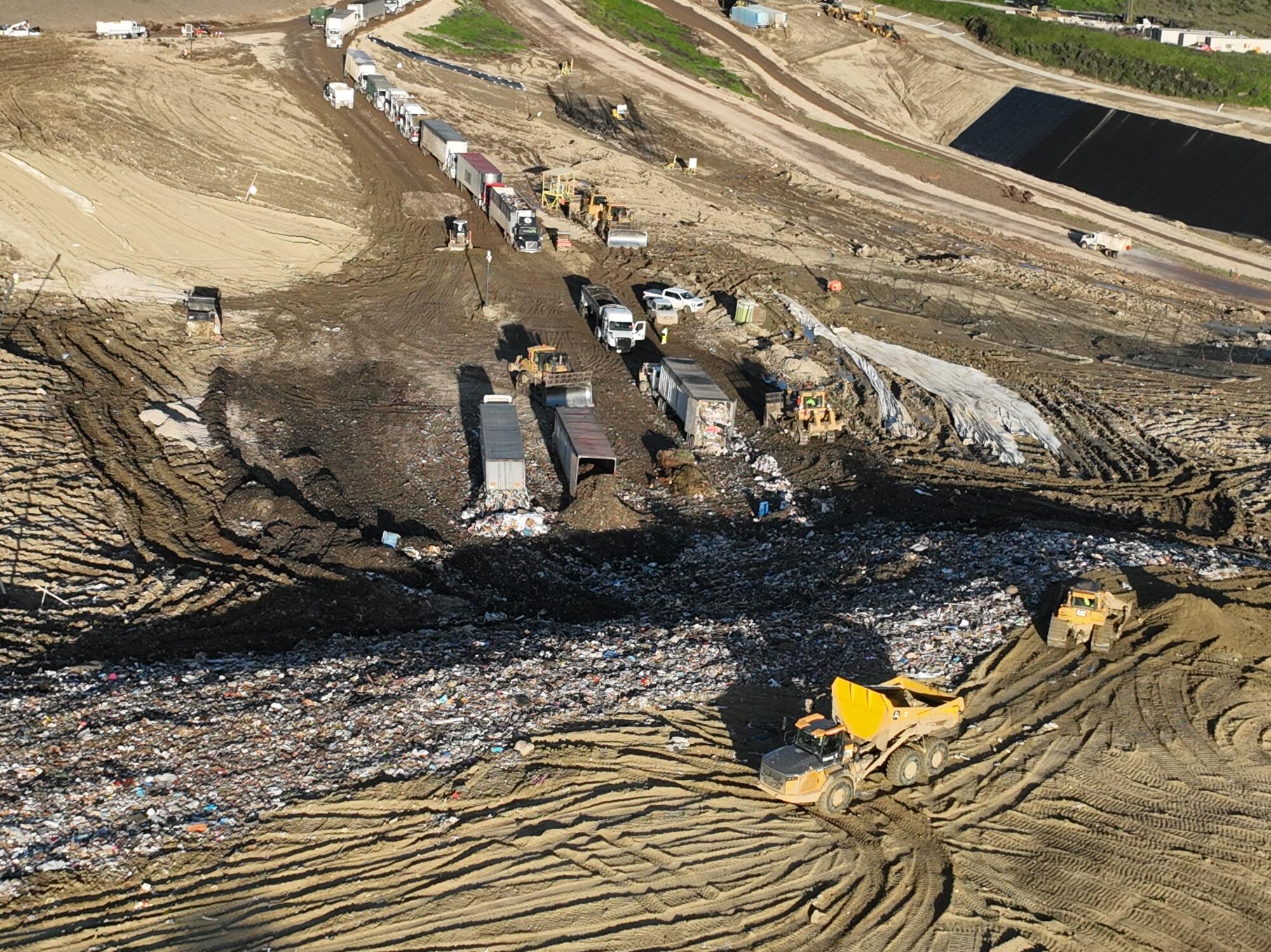 An aerial view of trucks unloading, heavy equipment spreading trash over at Chiquita Canyon Landfill in Castaic.