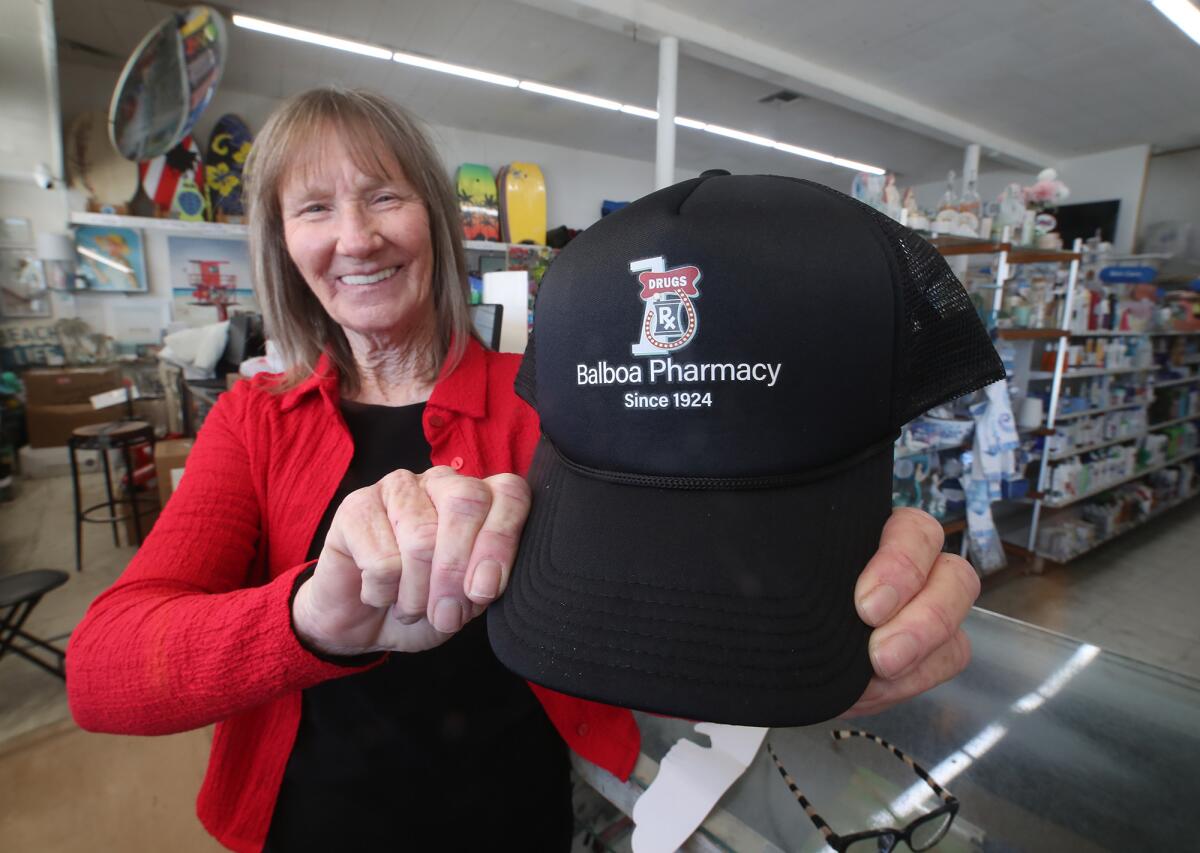 Store manager Kim Denger shows one of the hats that will be given to customers.