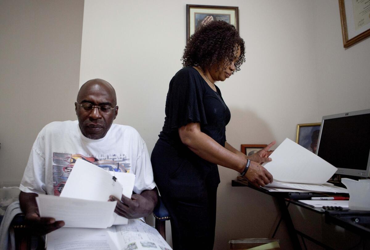 Michael and Patricia Jackson sift through bank documents at their home in Marietta, Ga. The Jacksons struggled to keep a house worth $100,000 less than they owed.