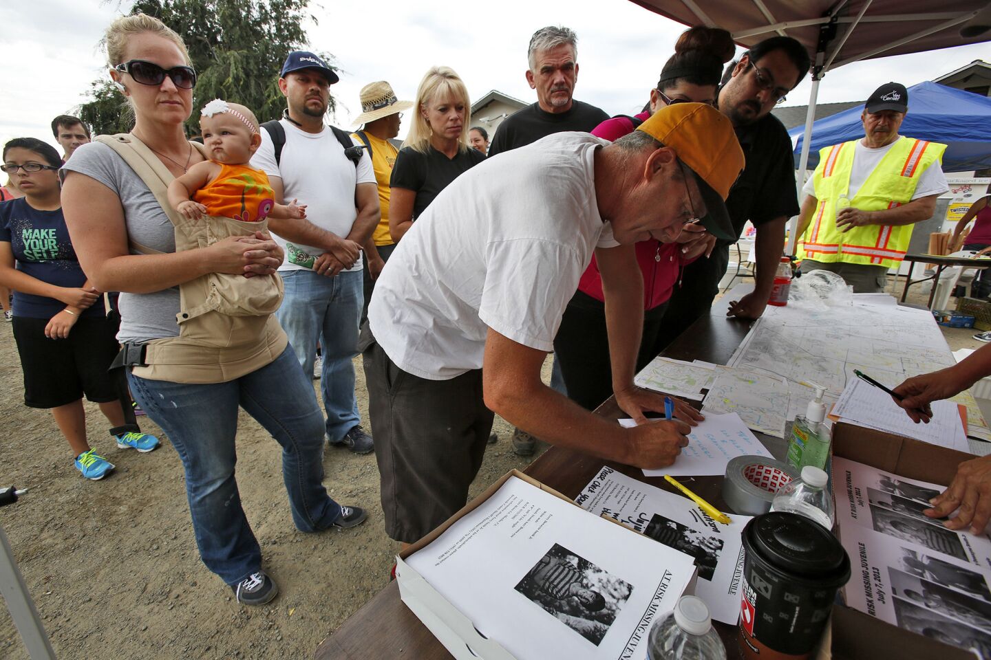 Bill Gillette signs in as scores of volunteers lined up Tuesday morning to join the search for 11-year-old Terry Dewayne Smith, who was last seen Saturday.