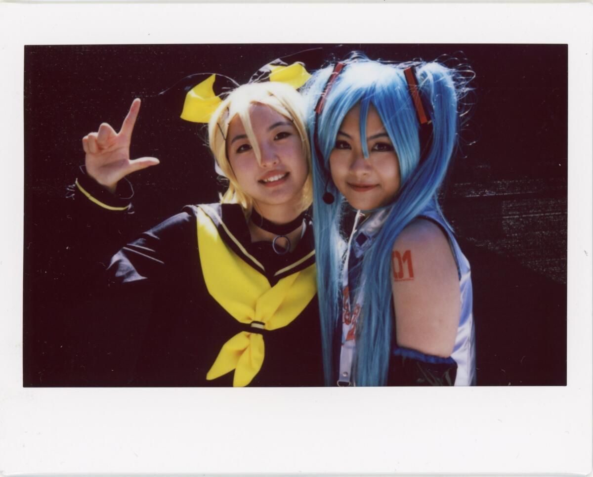 Two smiling girls, one with yellow hair and one with blue hair.