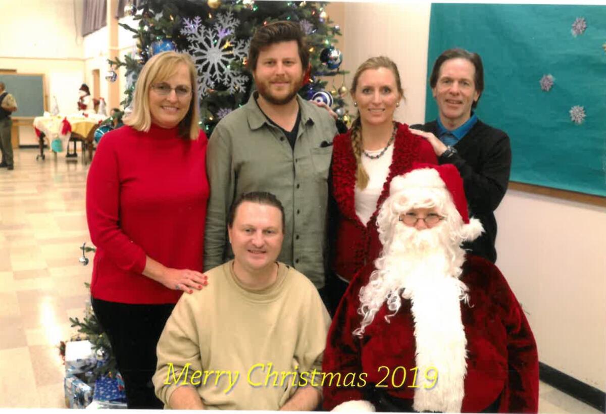A family poses with Santa with the text "Merry Christmas 2019."