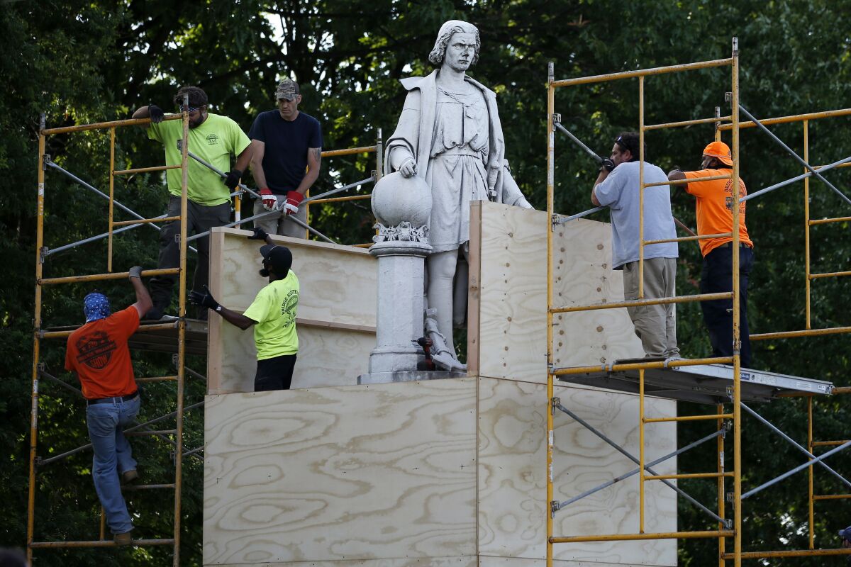 City workers cover a similar statue of Christopher Columbus in Philadelphia on Tuesday.