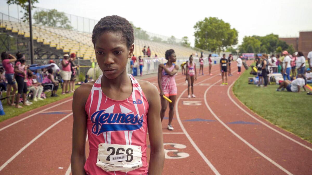 Women stand at starting points on a track.