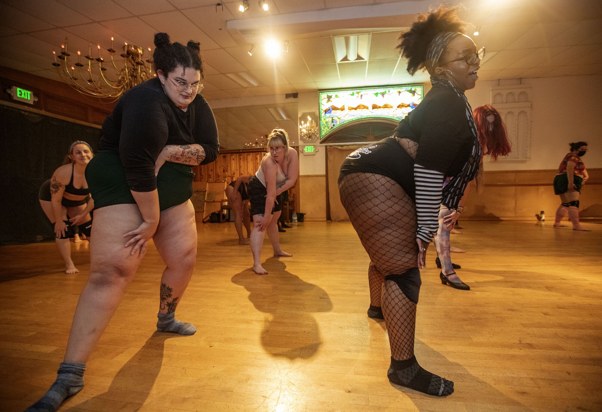 Two women dance in a workshop.
