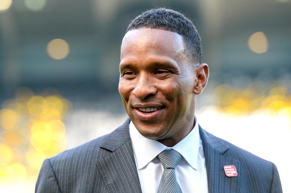 A head-and-shoulders horizontal frame of Shaka Hislop, wearing suit and tie, smiling and looking to the left.